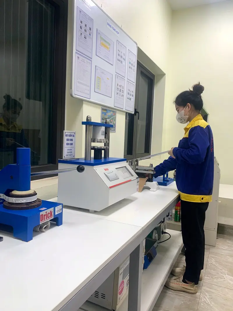 QC staff measuring ring and edge crush in the laboratory